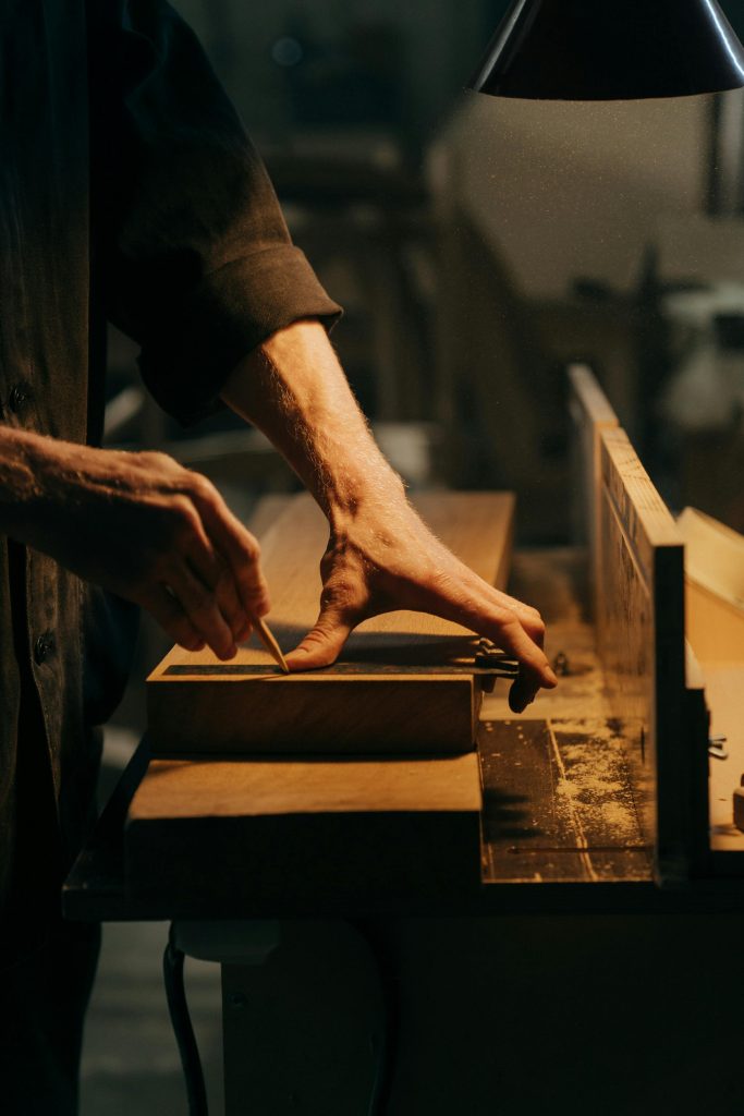pexels-photo-5089178-5089178 Person in Black T-shirt Holding Brown Wooden Table